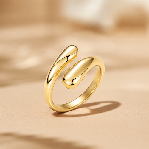 A Elnovaire polished gold ring with a modern, fluid, open spiral design, standing upright on a textured beige surface with a soft-focus background.